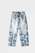 Light blue denim jeans with blue-white porcelain rose jacquard pattern and heavy distressing, wide-leg fit, front view on white background.